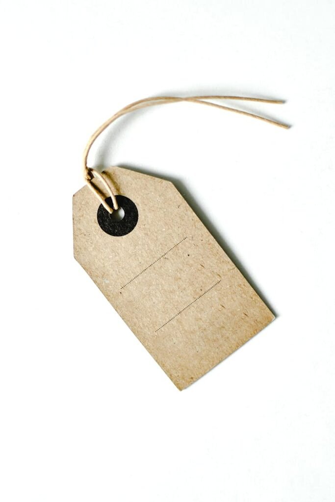 pexels photo 7965806 Simple brown paper tag with string on a white background, ideal for design.
